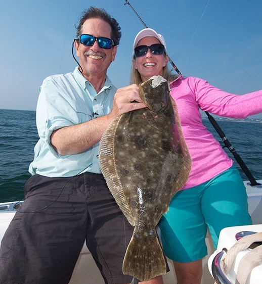 Capt. Dave Monti with Parker Kelly, co-host of New England Boating TV program, and a fluke caught while fishing Narragansett Bay, Rhode Island.