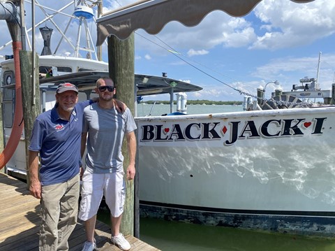 Father and son commercial fishermen Nick Carter and Bobby Carter stand in front of Bobby’s boat, the fishing vessel Black Jack I, where Nick started as a deckhand and worked his way up to captaining a sister vessel - the fishing vessel Jules.