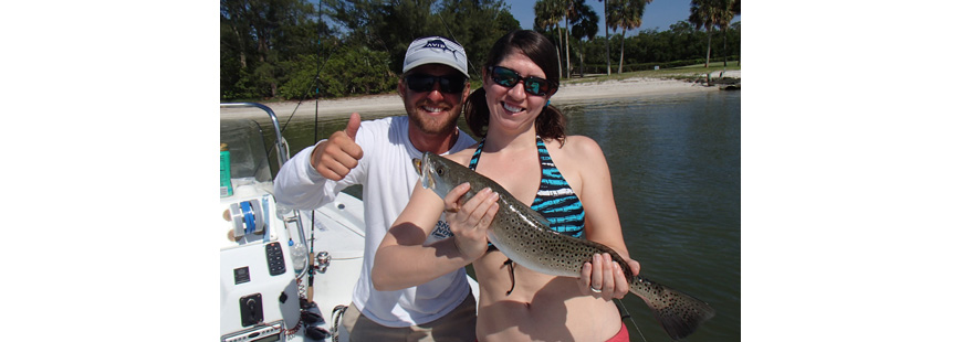 Teresa Gibson and Justin Rieger holding a spotted seatrout